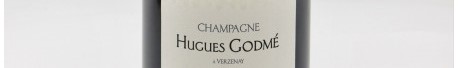 La photo montre une bouteille de champagne Hugues Godme en Champagne