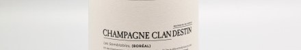 La photo montre une bouteille de champagne du domaine Clandestin en Champagne